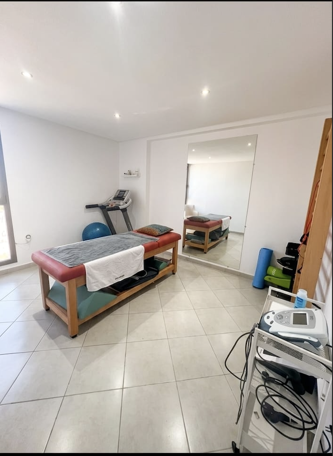 Plateau technique complet avec tapis de course, miroir de posture et tables de traitement chez Kiné Expert